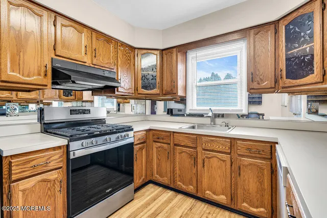 a kitchen with cabinets wooden floor and stainless steel appliances