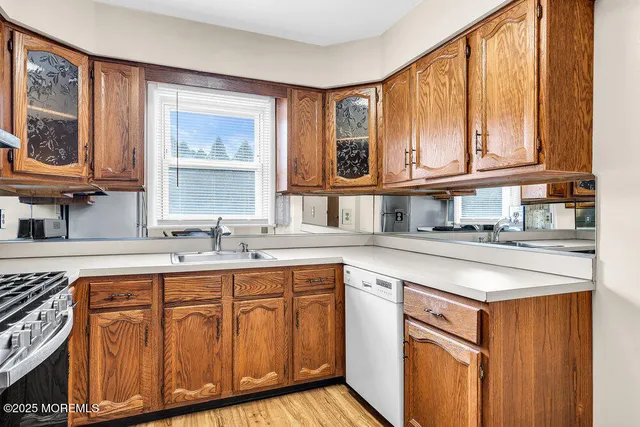 a kitchen with stainless steel appliances granite countertop a sink and cabinets with wooden floor