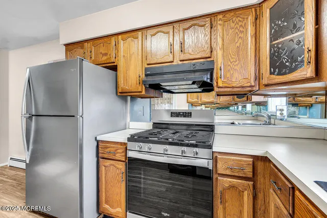 a kitchen with stainless steel appliances granite countertop a refrigerator stove and sink