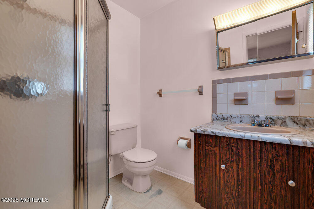 50 Oakfield Road Toms River, NJ 08757 - Photo 28 of 33 a bathroom with a toilet a sink and mirror