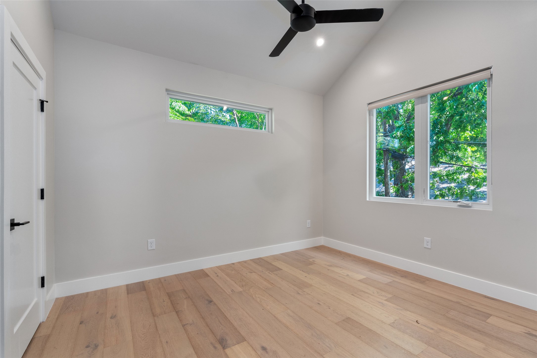 5200 Grover Avenue Austin, TX 78756 - Photo 16 of 32 Primary Bedroom featuring vaulted ceilings, wood-finish flooring, and multiple windows. Features a walk-in closet