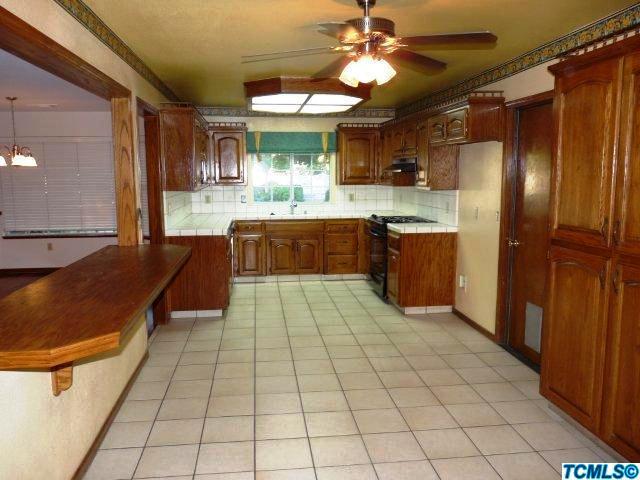 733 South Anderson Road Exeter, CA 93221 - Photo 5 of 17 a large kitchen with stainless steel appliances granite countertop a sink and cabinets