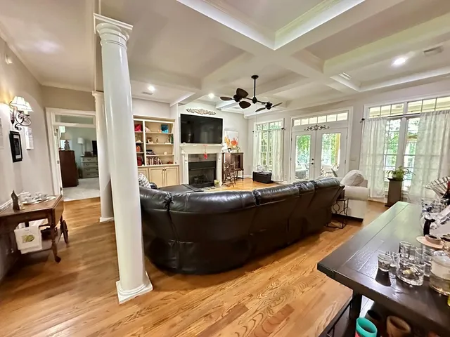 a dining room with wooden floor a chandelier a wooden table and chairs