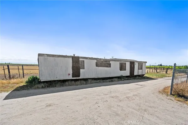 a view of a yard with wooden fence