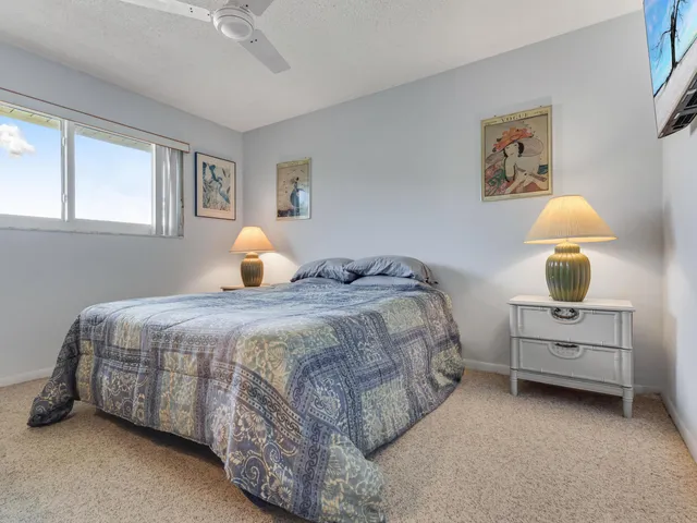 a bedroom with a bed and a lamp on dresser