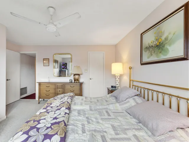 a bedroom with a bed and dresser with mirror