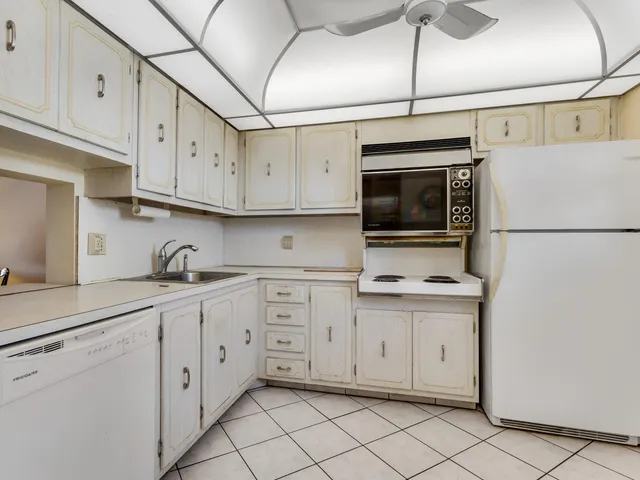 a kitchen with white cabinets a sink and dishwasher