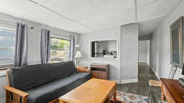 a living room with furniture a flat screen tv and a window