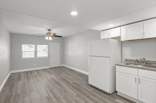 a view of a kitchen with a white cabinet and wooden floor