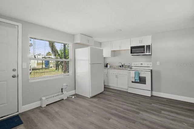 a kitchen with a refrigerator and a stove top oven