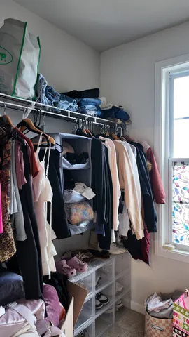 a view of walk in closet with clothes and shoes