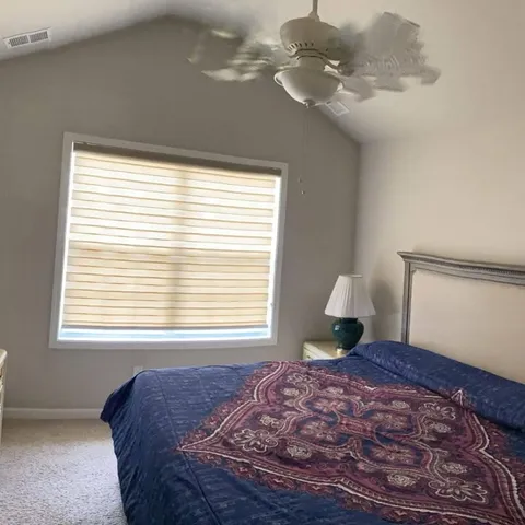 a bedroom with a bed chandelier and a window