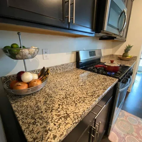 a kitchen with a stove and a wooden floor