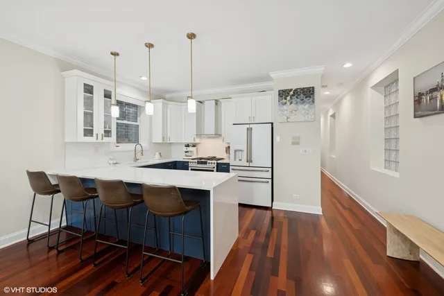 a kitchen with stainless steel appliances granite countertop a white cabinets and wooden floor