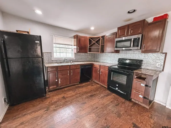 a kitchen with stainless steel appliances granite countertop a refrigerator stove and sink