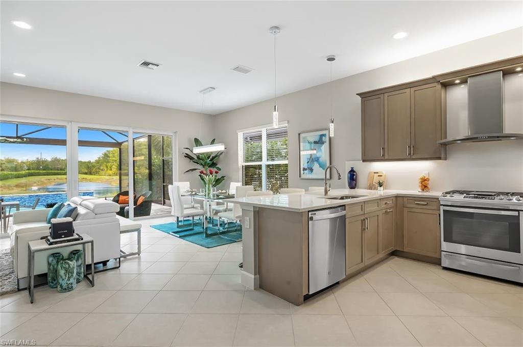 11311 Jacaranda Drive Naples, FL 34120 - Photo 14 of 50 a kitchen with stainless steel appliances granite countertop a stove and a sink