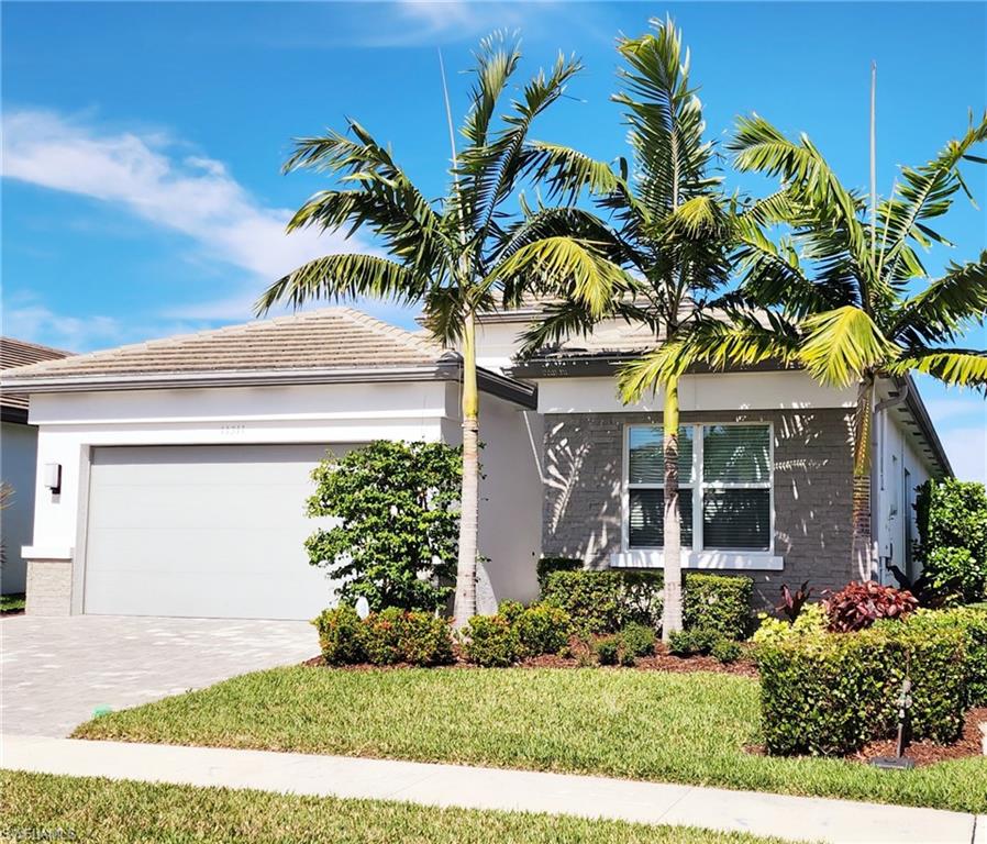 11311 Jacaranda Drive Naples, FL 34120 - Photo 2 of 50 a front view of a house with a garden