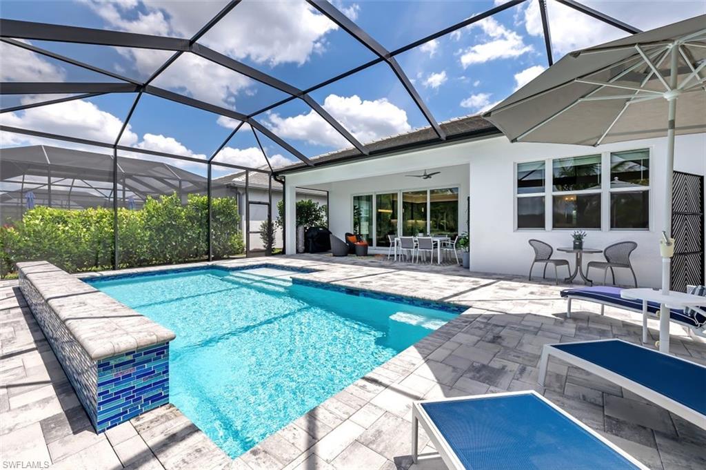11311 Jacaranda Drive Naples, FL 34120 - Photo 22 of 50 a swimming pool with outdoor seating and yard