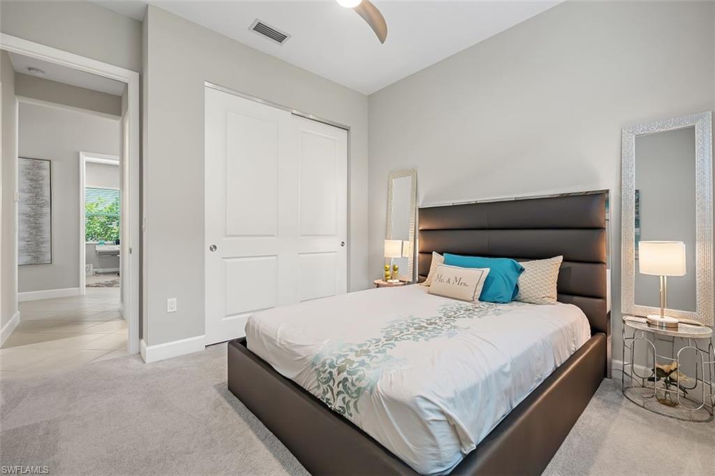 11311 Jacaranda Drive Naples, FL 34120 - Photo 30 of 50 a bedroom with a bed and a lamp
