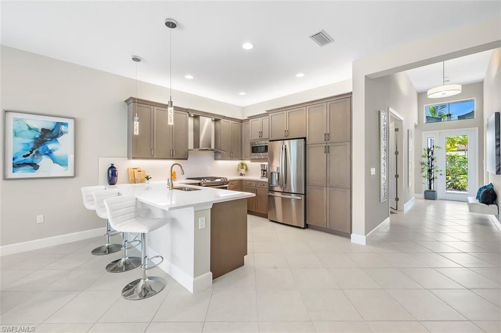 11311 Jacaranda Drive Naples, FL 34120 - Photo 6 of 50 a large kitchen with a table and chairs