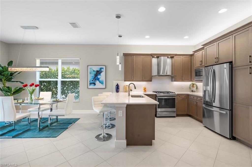 11311 Jacaranda Drive Naples, FL 34120 - Photo 8 of 50 a kitchen with kitchen island granite countertop a sink counter and chairs