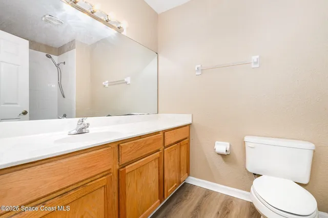 a bathroom with a granite countertop toilet sink and a mirror