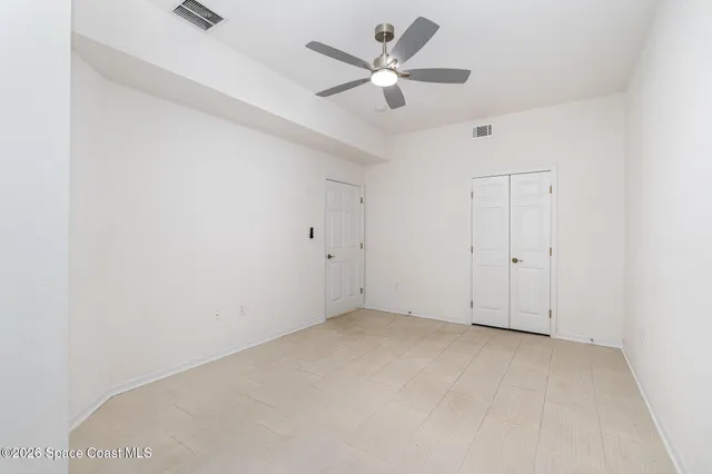 an empty room with a ceiling fan and a window