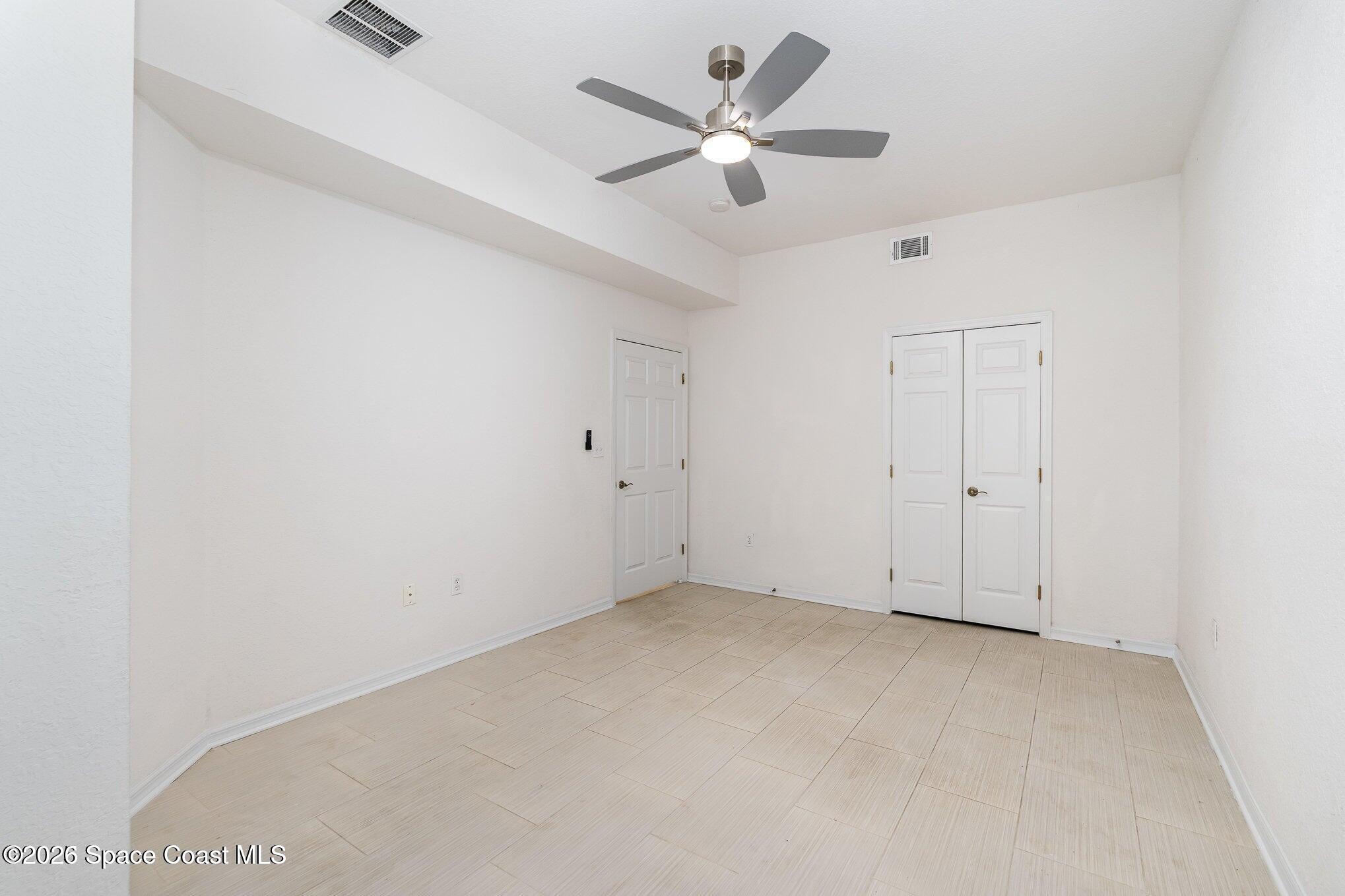 110 Colibri Way, Unit 106 Melbourne, FL 32901 - Photo 9 of 28 an empty room with a ceiling fan and a window