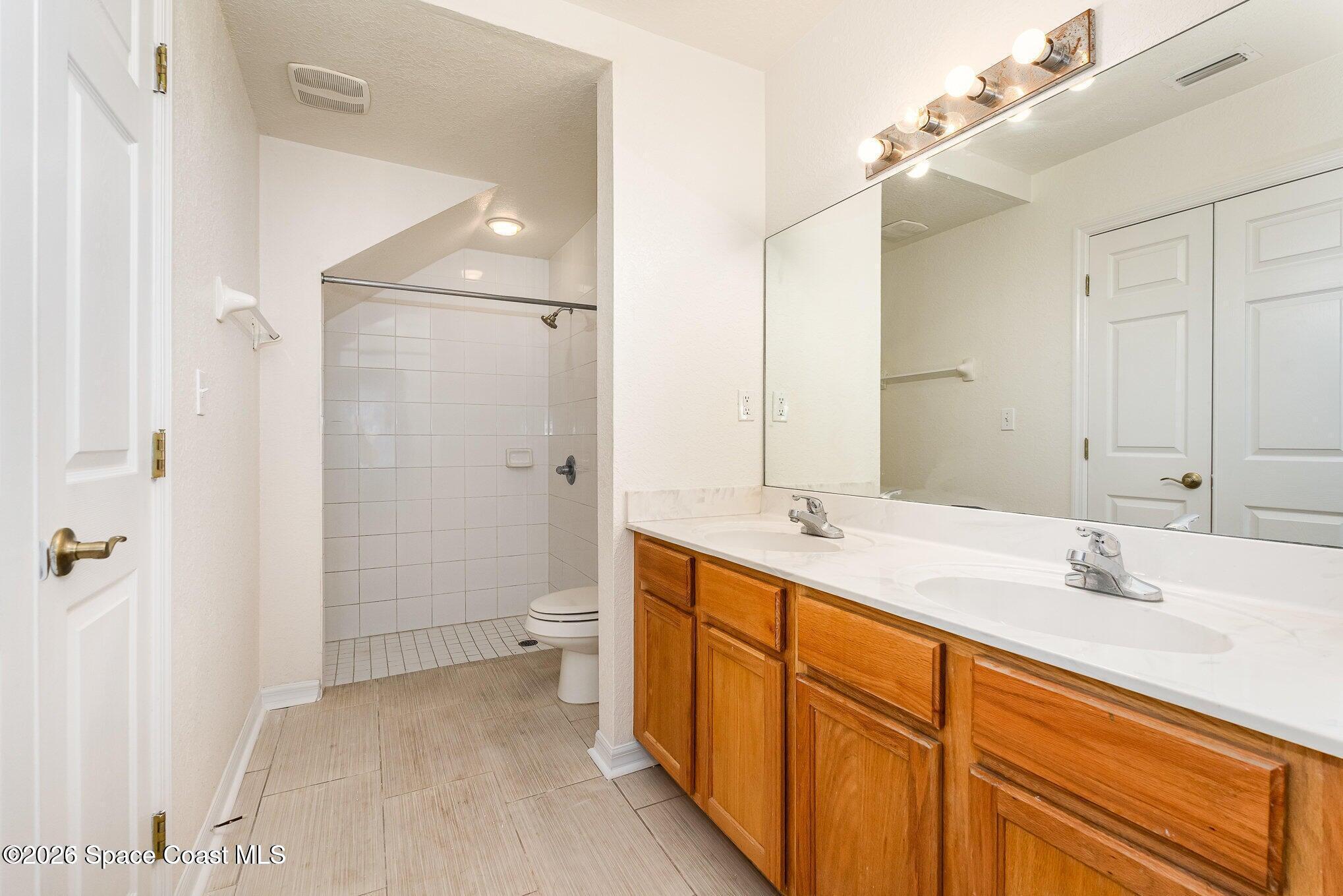 110 Colibri Way, Unit 106 Melbourne, FL 32901 - Photo 10 of 28 a bathroom with a double vanity sink mirror double and shower