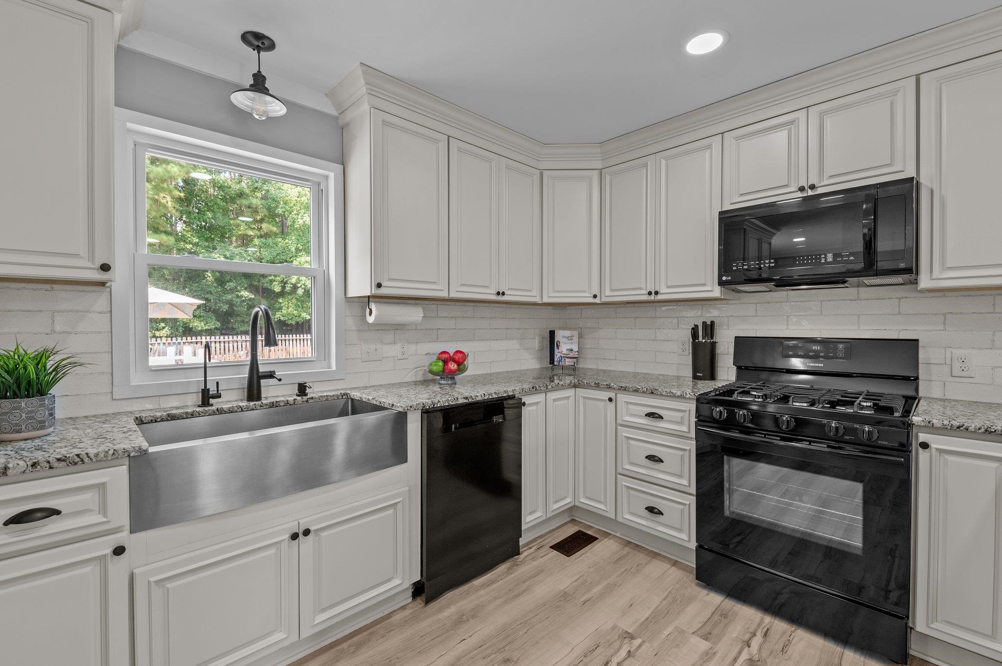 2037 Queen Charlotte Place Raleigh, NC 27610 - Photo 9 of 32 a kitchen with white cabinets appliances a sink and a window