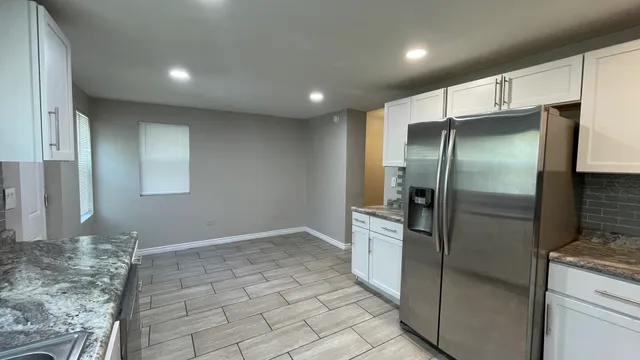 a modern kitchen with stainless steel appliances granite countertop a refrigerator and a sink