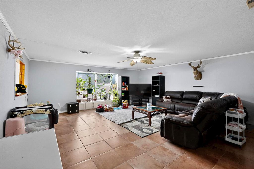 418 Hillside Drive Gainesville, TX 76240 - Photo 12 of 39 a living room with furniture and a flat screen tv