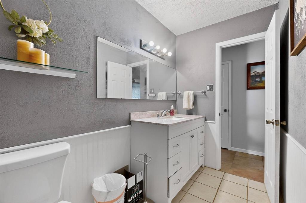 418 Hillside Drive Gainesville, TX 76240 - Photo 17 of 39 a bathroom with a sink vanity and mirror
