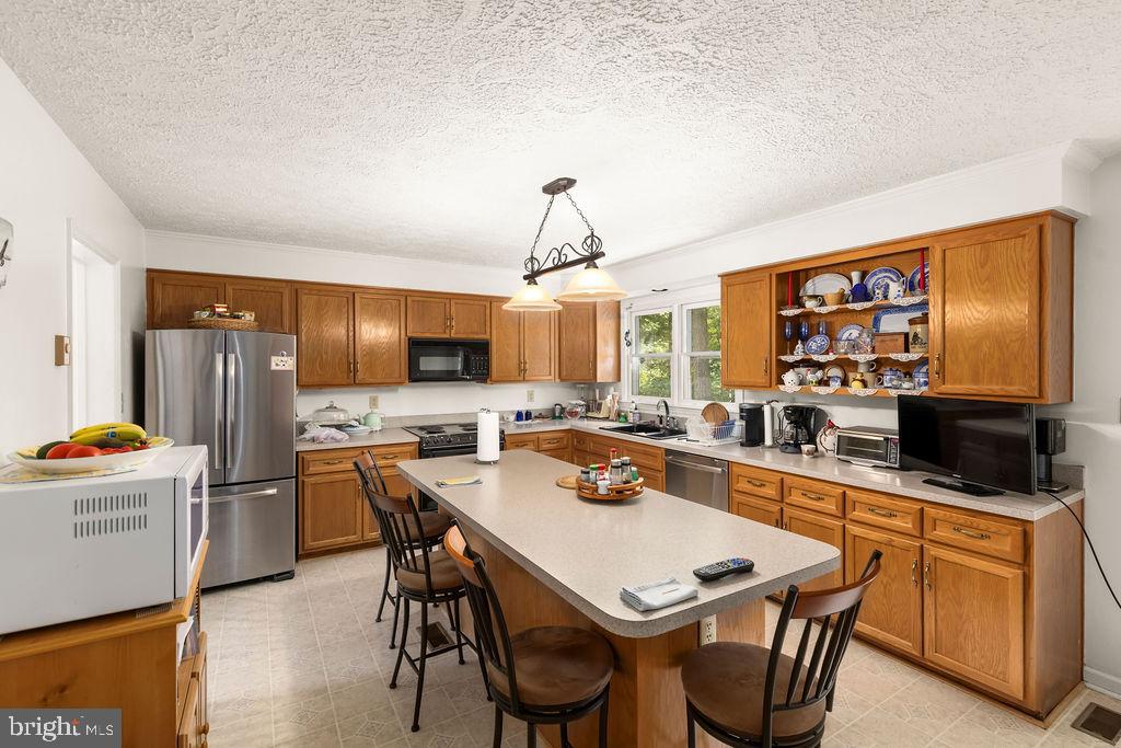 1115 Chapel Road Middletown, VA 22645 - Photo 25 of 54 a kitchen with stainless steel appliances a stove a sink dishwasher and white cabinets with wooden floor