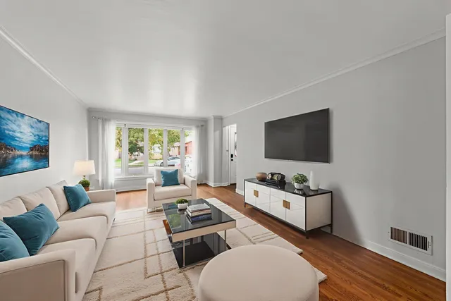 a living room with furniture a flat screen tv and a window