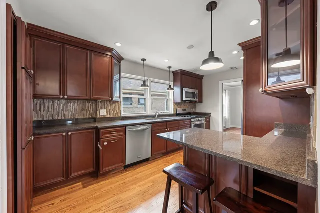 a open kitchen with stainless steel appliances granite countertop a sink a stove and a refrigerator