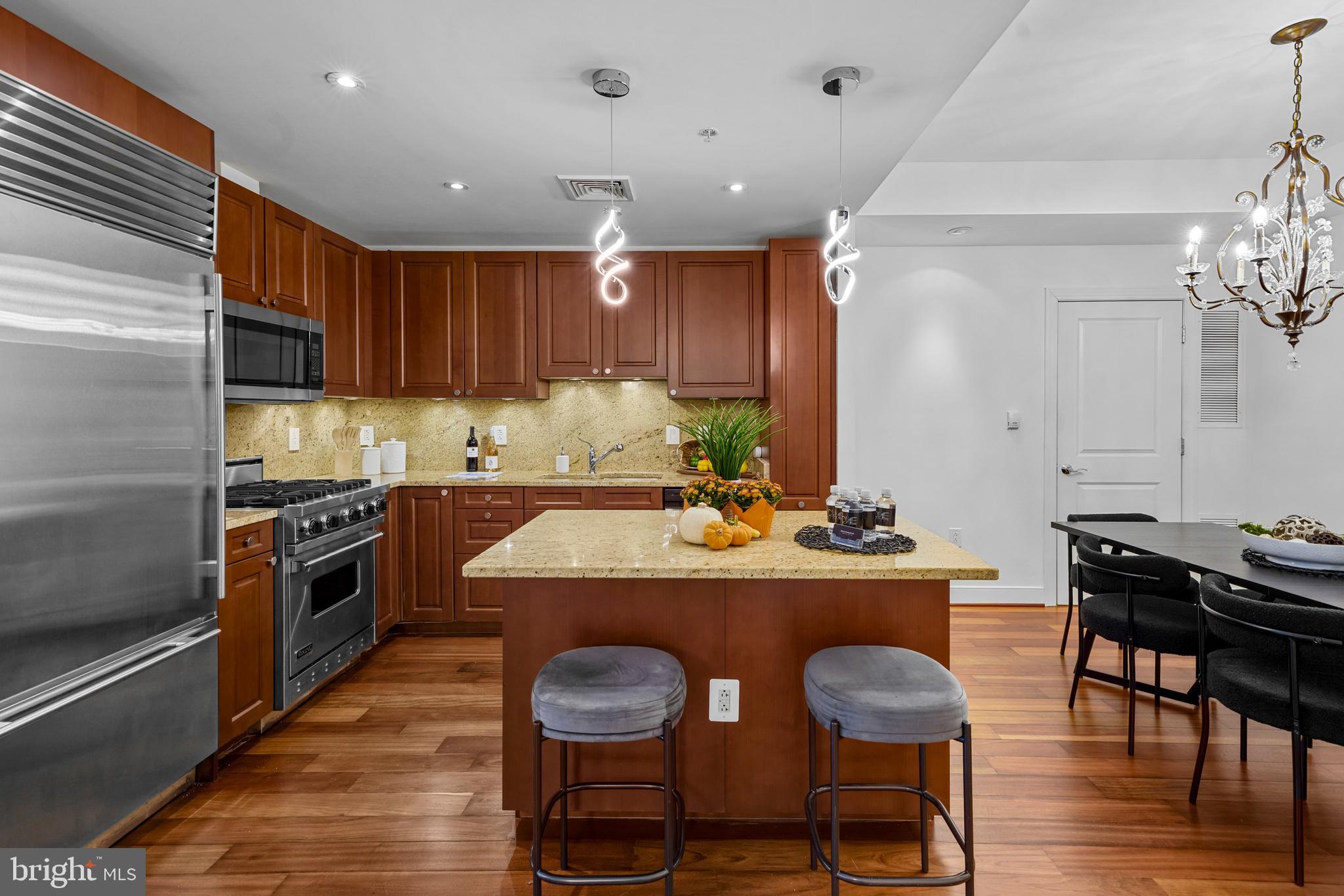 2425 L Street Northwest, Unit 431 Washington, DC 20037 - Photo 16 of 29 a kitchen with kitchen island granite countertop lots of counter top space and stainless steel appliances
