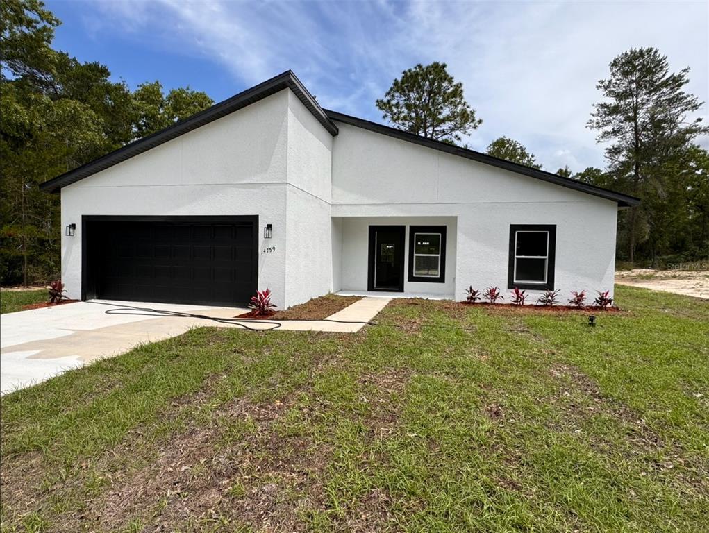 14759 Southwest 43rd Terrace Road Ocala, FL 34473 - Photo 1 of 1 a view of a house with a yard and garage