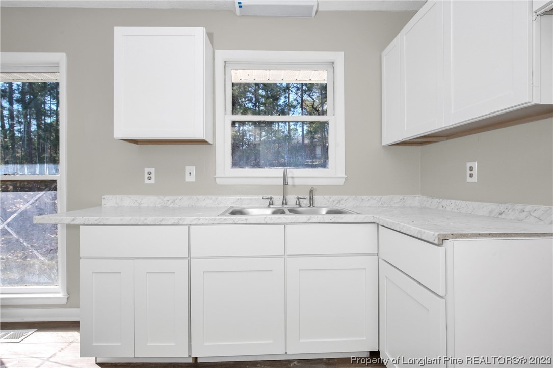 3319 Hedgemoor Circle Spring Lake, NC 28390 - Photo 15 of 30 a sink with white cabinets and a window