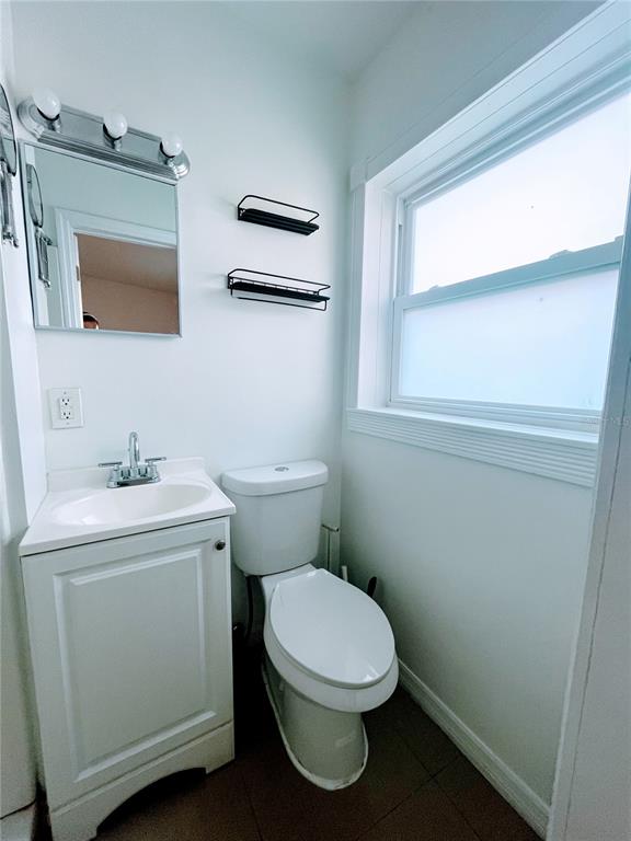 5910 Indian Hill Road Orlando, FL 32808 - Photo 9 of 12 a bathroom with a toilet sink and mirror