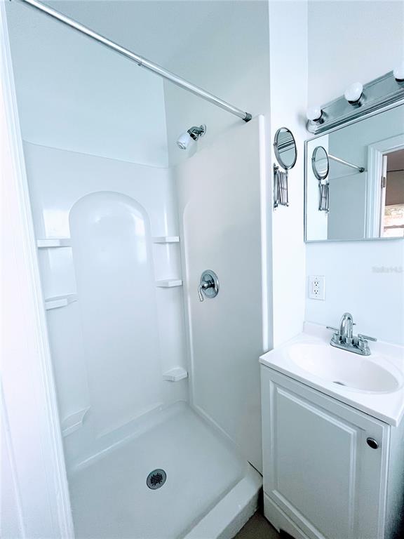 5910 Indian Hill Road Orlando, FL 32808 - Photo 10 of 12 a bathroom with a shower a sink and a mirror