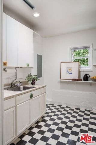 a kitchen with a checkered floor and white cabinets