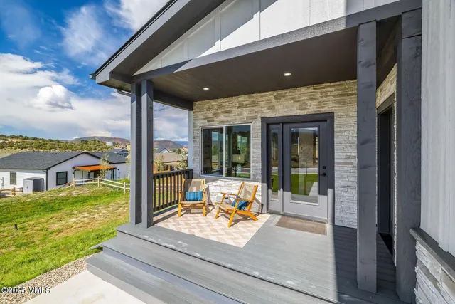 a view of a patio with table and chairs potted plants with wooden floor and fence