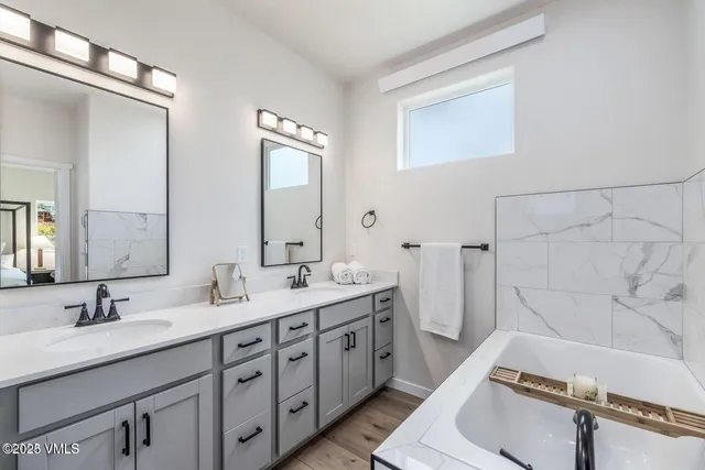 a bathroom with a double vanity sink a mirror and a shower