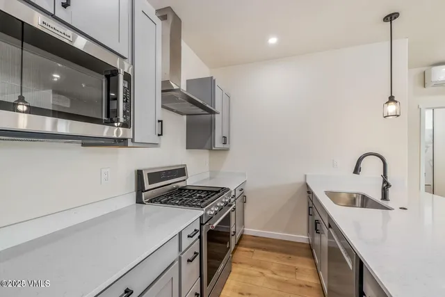 a kitchen with stainless steel appliances a sink stove and microwave