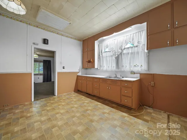 a room with granite countertop a sink and cabinets
