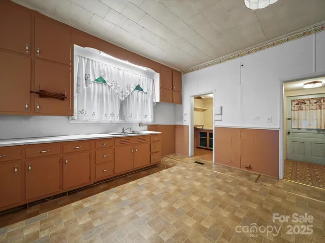 a kitchen with granite countertop a refrigerator and cabinets