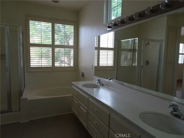 a bathroom with a granite countertop sink a mirror and a bathtub
