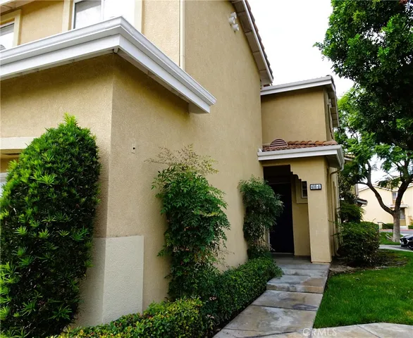 a view of a house with large windows and plants