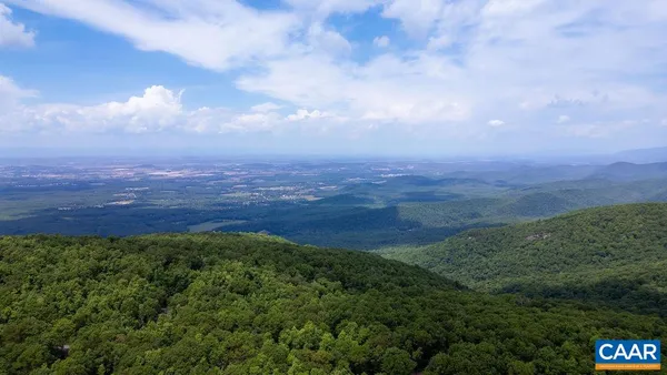 a view of a field with mountains in the background